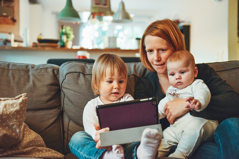 Mother with two little kids looking at a tablet